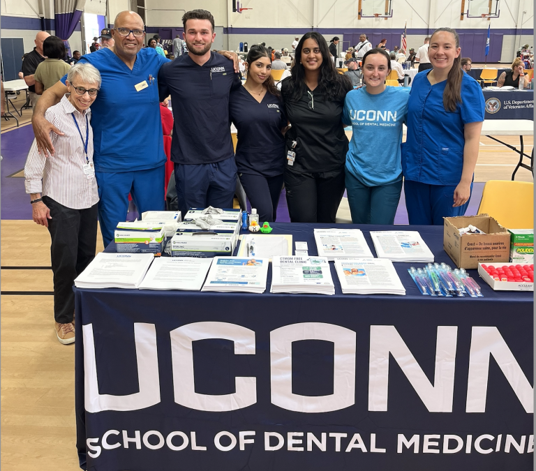 seven dentists during an event behind a table